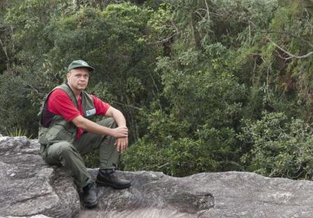 Dr. Ary Oliveira-Filho sitting on a rock while on field work